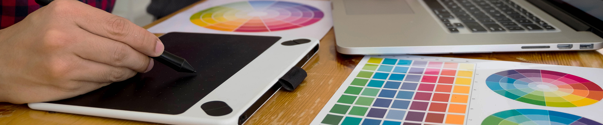 graphic designers looking at color papers and sketching on tablets