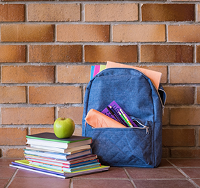 backpack with school supplies and stack of books