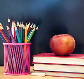 colored pencils and books with apple on it